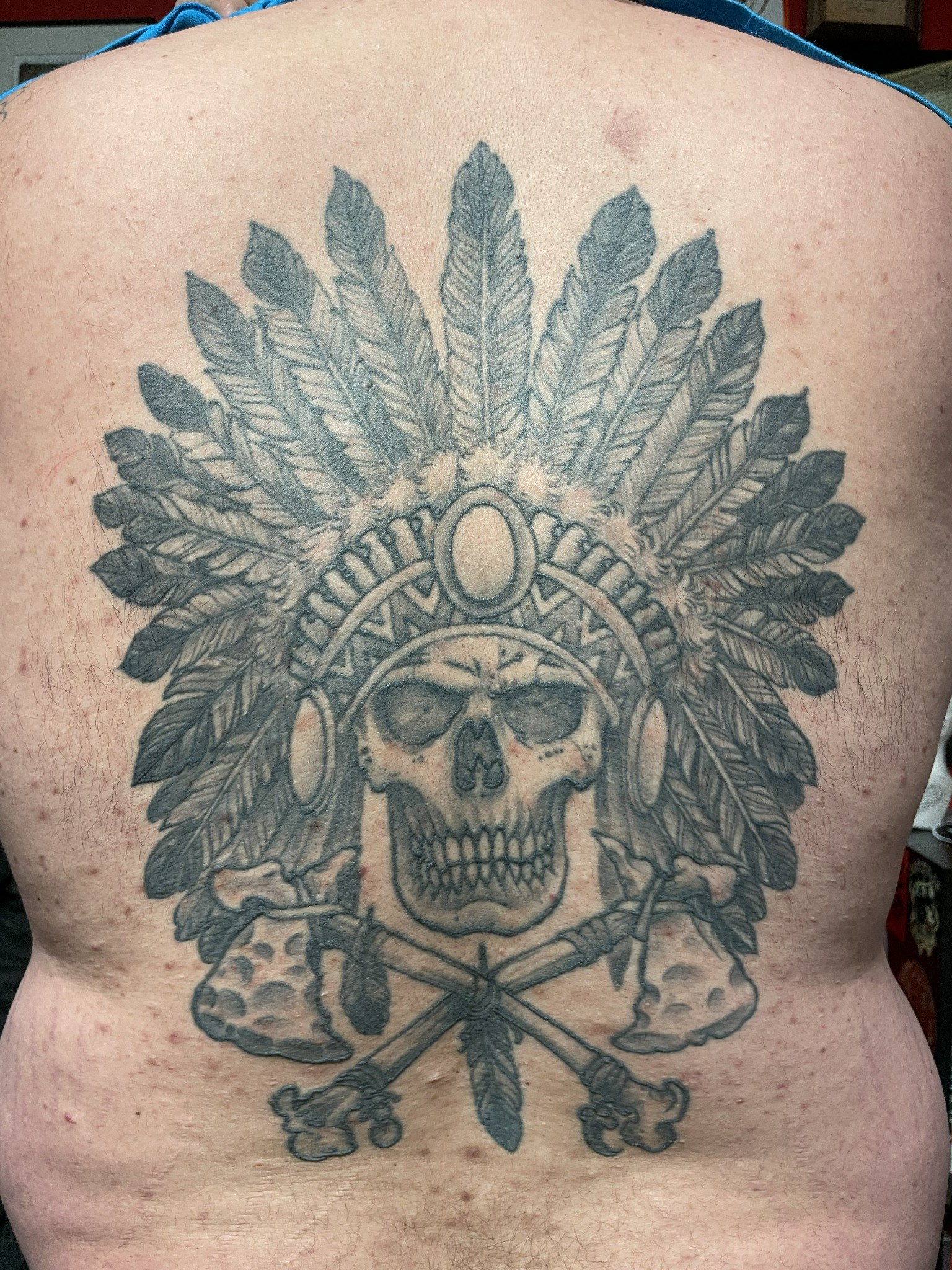 Black-and-gray skull feather headdress back by Dom at Last Hope Tattoo Company in Toledo