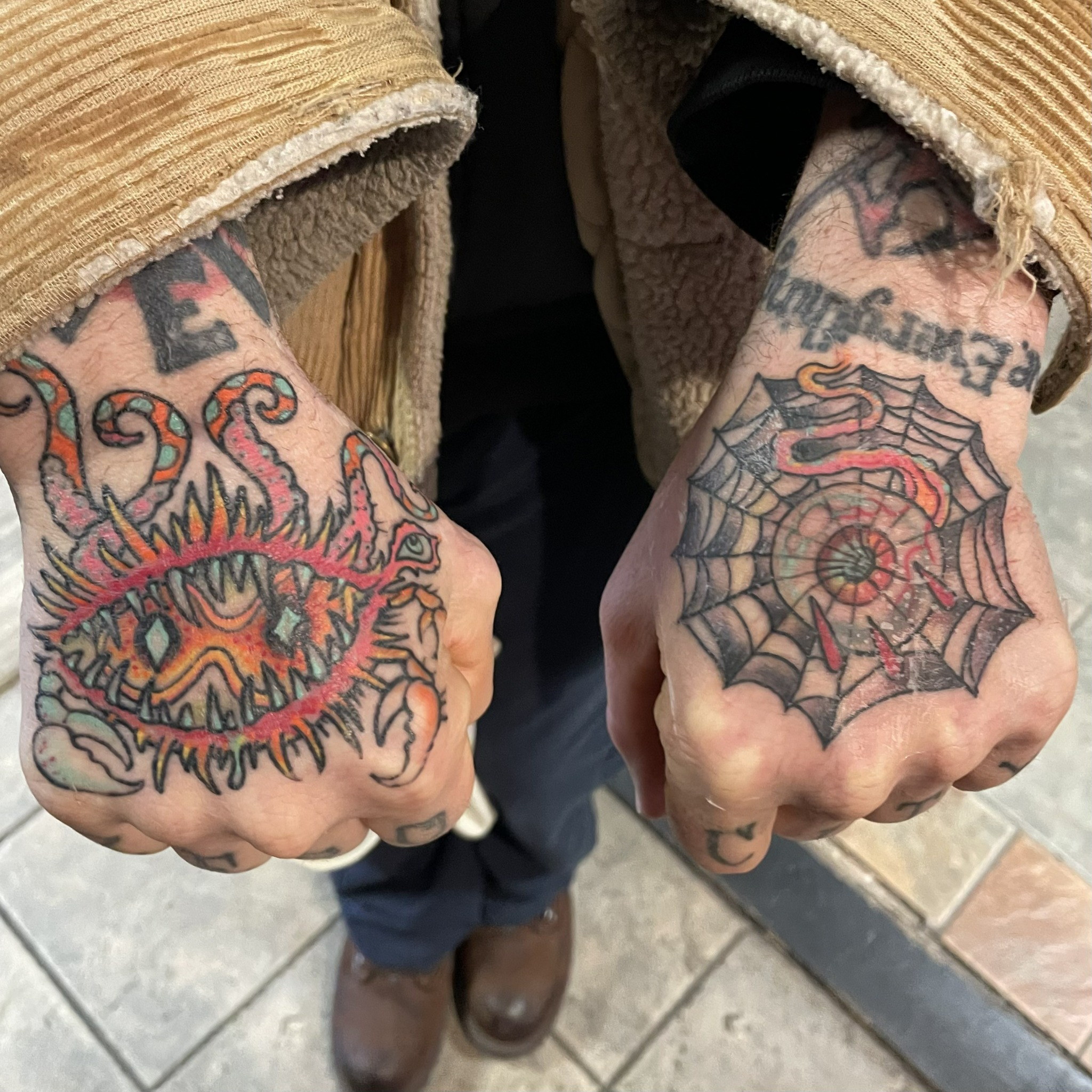 Color eye spiderweb hand tattoos by Dom at Last Hope Tattoo Company in Toledo